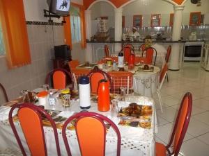 a dining room with a table and chairs with food on it at Nacional Hotel in Itacarambi