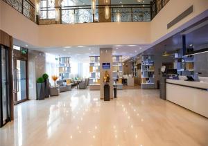 a lobby of a hospital with couches and tables at Echarm Hotel Zibo Gaoqing Zhongcheng Inernational in Zibo