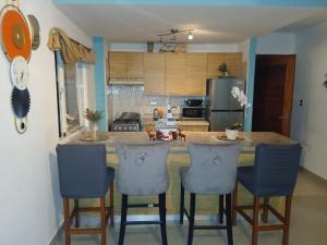 una cocina con isla con taburetes de bar en Serena Village Punta Cana 12 min away from PUJ Intl, en Punta Cana