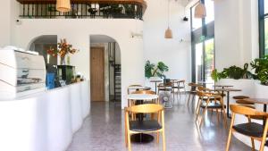a room with tables and chairs in a restaurant at Monstera Hotel and Coffee in Phú Quốc