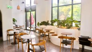 a row of tables and chairs in a room with windows at Monstera Hotel and Coffee in Phú Quốc +48 photos