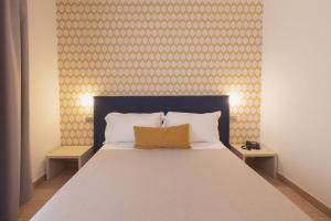 a bedroom with a bed with a blue headboard and two tables at River Side & Swimming pool in Udawalawe