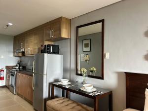 une cuisine avec un réfrigérateur en acier inoxydable et une table dans l'établissement Crosswinds Resort Studio Double Suite, à Ulot