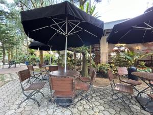 une table et des chaises avec un parasol sur une terrasse dans l'établissement Crosswinds Resort Studio Double Suite, à Ulot