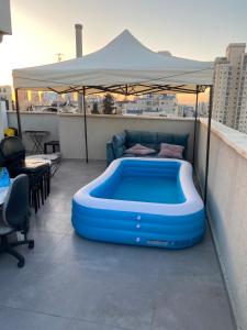 a large blue tub sitting on top of a balcony at פנטהאוז in Petaẖ Tiqwa