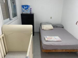 a small room with two beds and a window at פנטהאוז in Petaẖ Tiqwa +2 photos