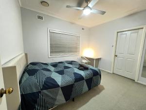 a bedroom with a bed and a ceiling fan at Cozy Queen Room in Two Story House - R2 in Sydney