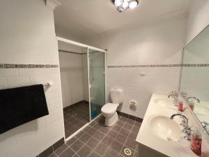a bathroom with a toilet and a sink and a shower at Cozy Queen Room in Two Story House - R2 in Sydney