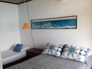 a bedroom with a bed and a picture on the wall at Casa Angra dos Reis in Angra dos Reis