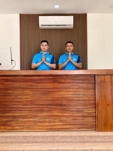 two men in blue shirts are standing behind a desk at Song View Pool Villa in Vang Vieng +90 photos