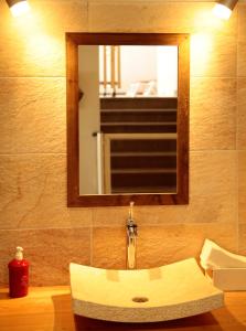 ein Badezimmer mit einem Waschbecken, einem Spiegel und einem Waschbecken in der Unterkunft Hôtel Soleil des Neiges in Le Sauze