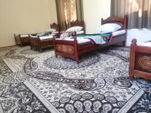 a room with three beds and a rug at Qokhna Samarqand in Samarkand +7 photos