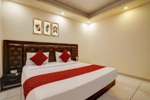 a bedroom with a large bed with red pillows at Hotel Grand Lowsan Airport in New Delhi +19 photos