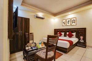 a hotel room with a bed and a desk with a chair at Hotel Grand Lowsan Airport in New Delhi