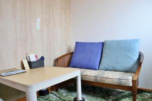 a couch sitting in a living room with a table at ゲストハウスＰｉｋｏ in Shingū