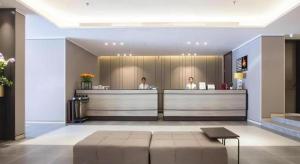 a lobby with two people sitting at a counter at Yitel Zhige Hotel Sanya Haowei Qilin in Sanya