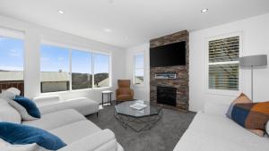 a living room with white furniture and a fireplace at Absollut 2 in Mount Hotham