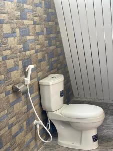 a bathroom with a toilet with a hose at River Side & Swimming pool in Udawalawe