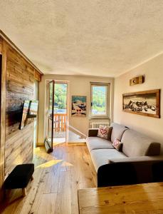 a living room with a couch and a wooden wall at Nido Alpino - Vista Montagne e Relax Terme a 150m in Pré-Saint-Didier