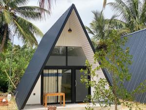 a small house with a black roof at River Side & Swimming pool in Udawalawe