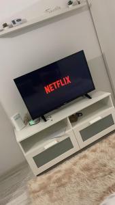 a flat screen tv sitting on a white entertainment center at apartament 1 camera in Roşu +1 photo