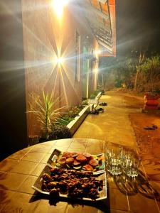 een dienblad met eten op een tafel met wijnglazen bij River stream Nest homestay in Madikeri