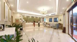 a person is standing in a large lobby at Vienna Hotel Guangdong Foshan Shunde Longjiang Material City in Shunde