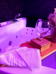 a bath tub with a wine glass and a towel at Heavenly Love in Yvetot