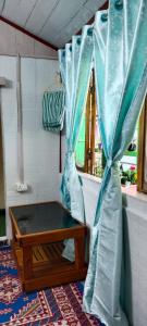 a room with a table and a blue curtain at Lali Guras Homestay Simana in Darjeeling