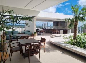 eine Terrasse mit Tischen und Stühlen auf einem Gebäude in der Unterkunft DEPARTAMENTO MODERNO EN EQUIPETROL DE LUJO CERCA DE MALL, SUPERMECADOS, VENTURA MALL y en la zona mas exclusiva de Santa Cruz in Santa Cruz de la Sierra