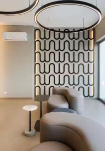 ein Wohnzimmer mit einer Couch und einem Kronleuchter in der Unterkunft DEPARTAMENTO MODERNO EN EQUIPETROL DE LUJO CERCA DE MALL, SUPERMECADOS, VENTURA MALL y en la zona mas exclusiva de Santa Cruz in Santa Cruz de la Sierra + 31 Fotos