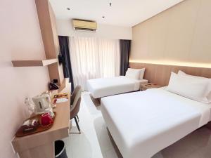 a hotel room with two beds and a desk at SHANKEE Sudirman in Jakarta +36 photos