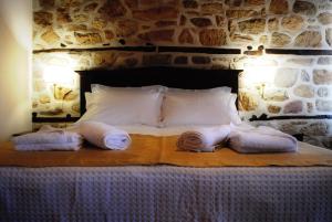 a bedroom with a bed with towels on it at Chorostasi Mansion in Arnaia