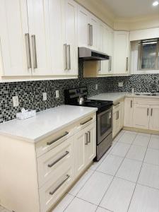 a kitchen with white cabinets and a stove at 5 mins walk to beach! Lovely, spacious bedroom near Beach, Stanley Park, Cypress Mountain, Downtown Vancouver, Grouse Mountain in West Vancouver