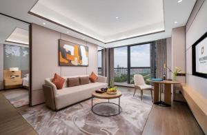 a living room with a couch and a table at Projoy Hotel Tianfu Chengdu in Zhongxingchang