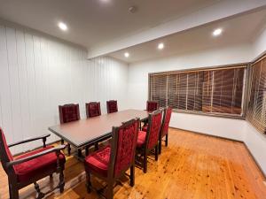 a dining room with a table and red chairs at Queen Room in Rydalmere - R4 in Sydney
