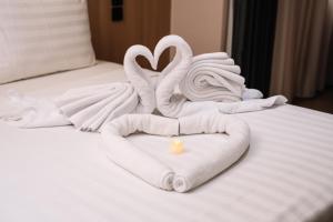 two swans made out of towels on a bed at SHANKEE Sudirman in Jakarta