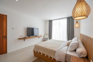 Μια τηλεόραση ή/και κέντρο ψυχαγωγίας στο Lovely Nyanyi 2 - 2BR Private Pool Villa in Nyanyi Near Nuanu