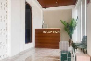 un hall d'entrée avec une porte de réception avec un panneau de maintien du mouvement dans l'établissement CIKOMI KOSTEL Syariah By Hans Management, à Tanjungkarang