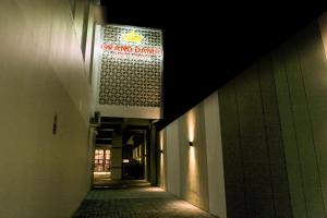 un couloir sombre avec un panneau sur le côté du bâtiment dans l'établissement Grand Damai Kostel Exclusive, à Ngaglik