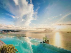 a swimming pool with a view of the water at MELLIA OCEANUS NHA TRANG BAY Five-Star Suites in Nha Trang