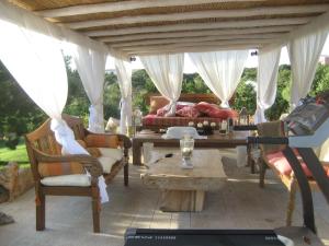 a patio with a couch and a table and chairs at Villa Dolce Vita in Cannigione