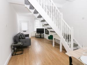 a living room with a staircase and a couch at Holly House in Whitehaven