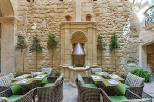 a restaurant with tables and chairs and a fireplace at Palazzo Consiglia - IK Collection in Valletta