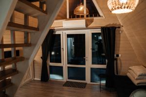 an attic room with a staircase and a glass door at В тиші Келечина in Kelechin