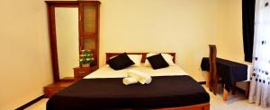 a bedroom with a bed with two pillows at Angel Haven Villa in Mirissa