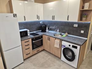 a kitchen with white cabinets and a washer and dryer at Apartment The Garden in Ruse +25 photos