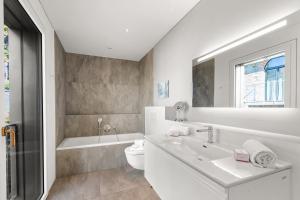 un bagno bianco con lavandino e WC di Villa Botta Minusio a Tenero-Contra Altre 36 foto