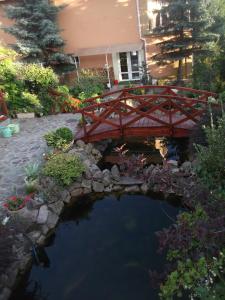 a wooden bridge over a pond in a garden at Pensiunea Raze De Soare in Oradea