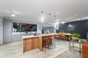 eine offene Küche und ein Wohnzimmer mit einer Bar mit Hockern in der Unterkunft Bird of Paradise in Tzaneen